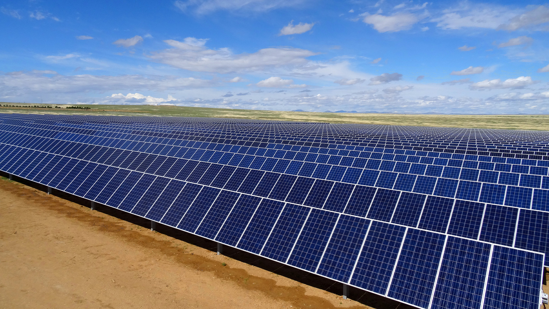 Rows of solar panels under a blue sky