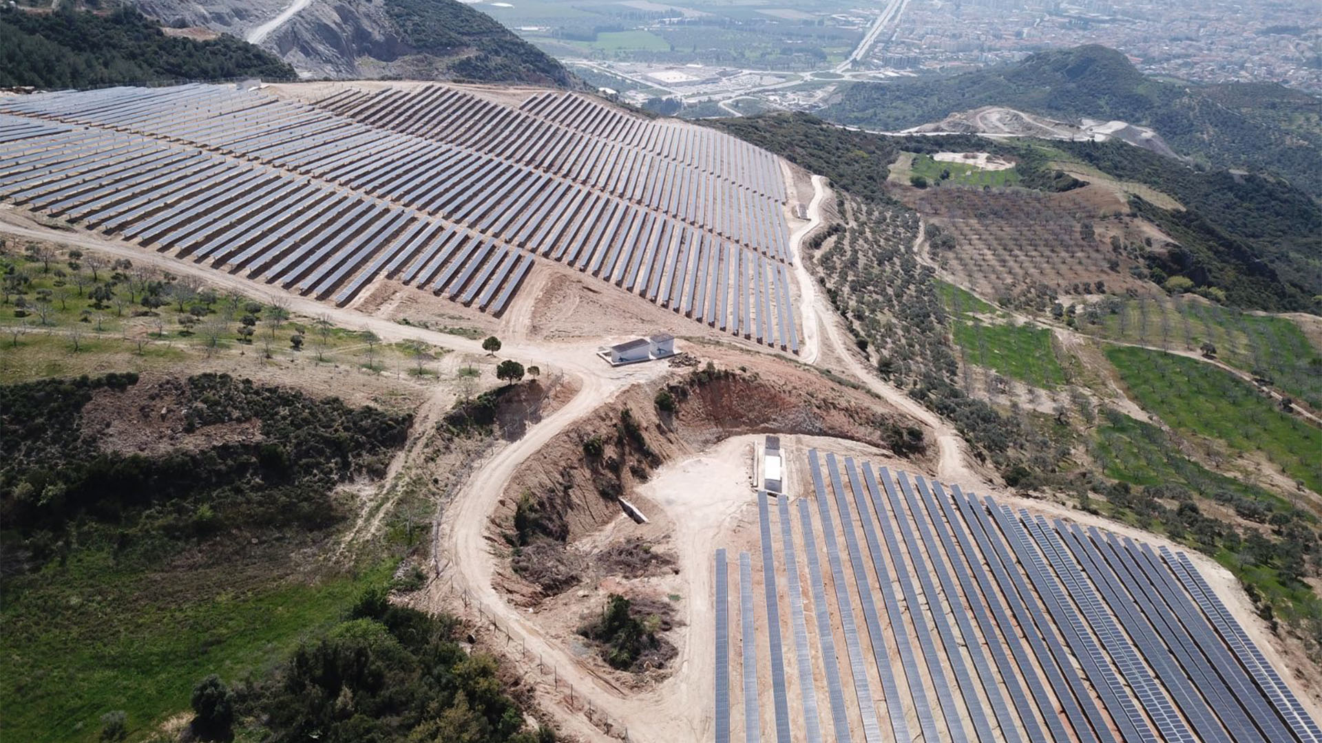 An aerial view of a solar site within a mountain range