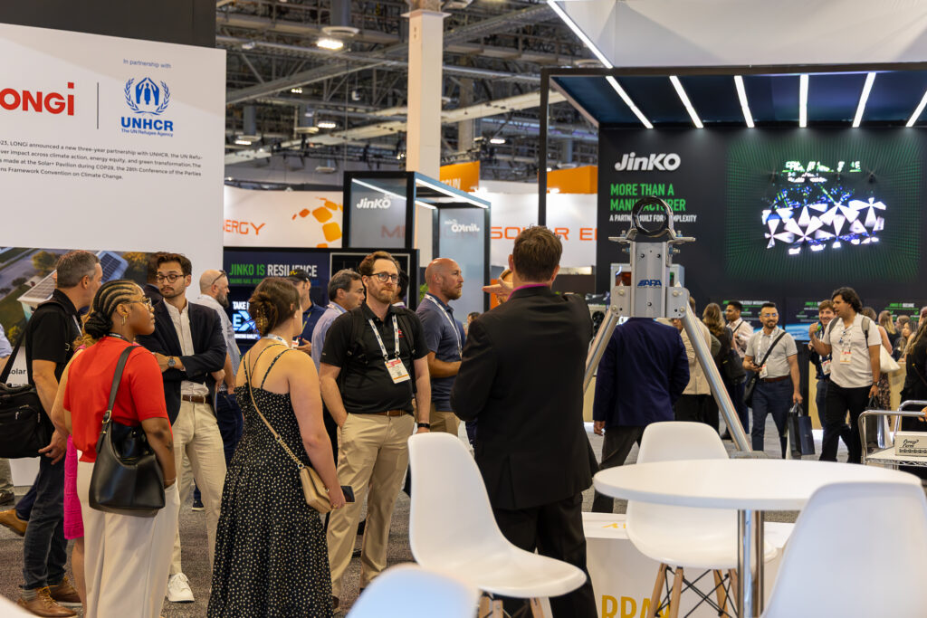 Crowd standing on RE+ tradeshow floors listening to a presenter